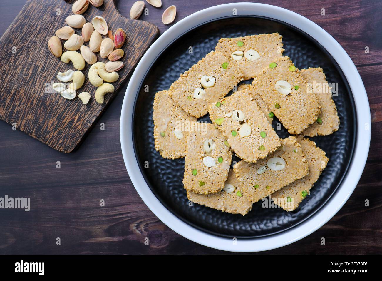 Til gajak, un doux plat d'hiver traditionnel indien fait avec des graines de sésame, du jaggery, du ghee et des fruits secs. Til chikki croquant, un Makar Sankranti festif. Banque D'Images