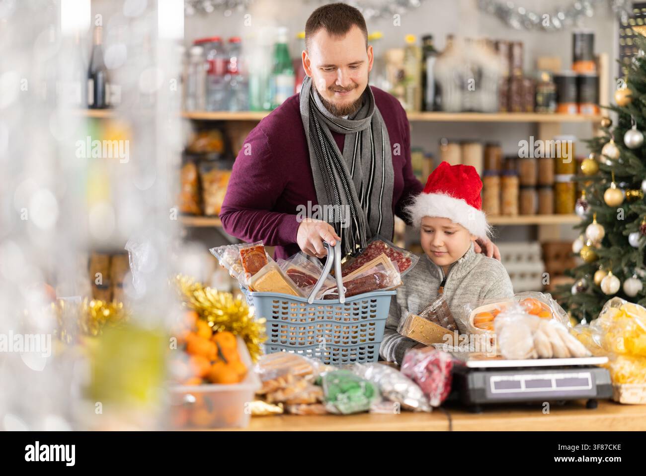 Papa et son fils choisissent des bonbons pour la célébration du nouvel an au supermarché Banque D'Images
