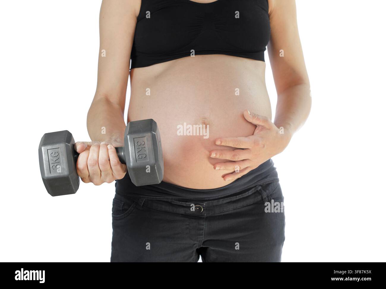Femme enceinte tenant un haltère Banque D'Images