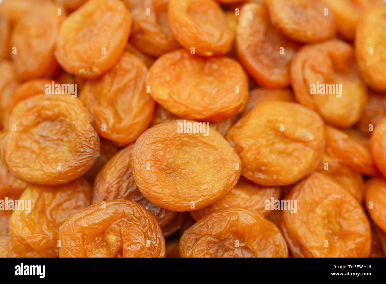 Abricots séchés empilés, en gros plan, avec des abricots séchés, vue de dessus, avec des accents orange, bruns, et naturel Banque D'Images