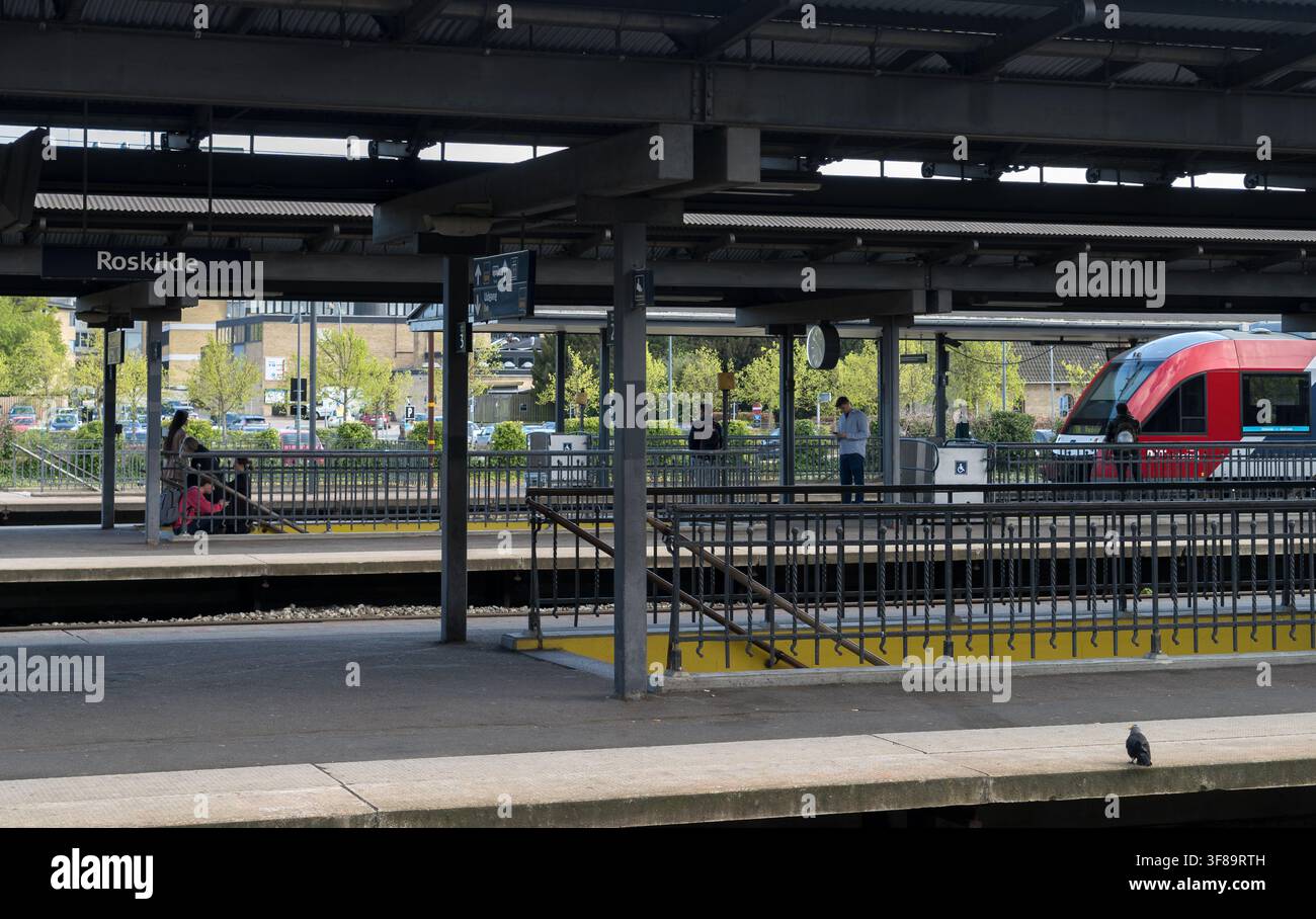 Train à la gare de Roskilde avec des passagers attendant sur le quai - Danemark. Banque D'Images