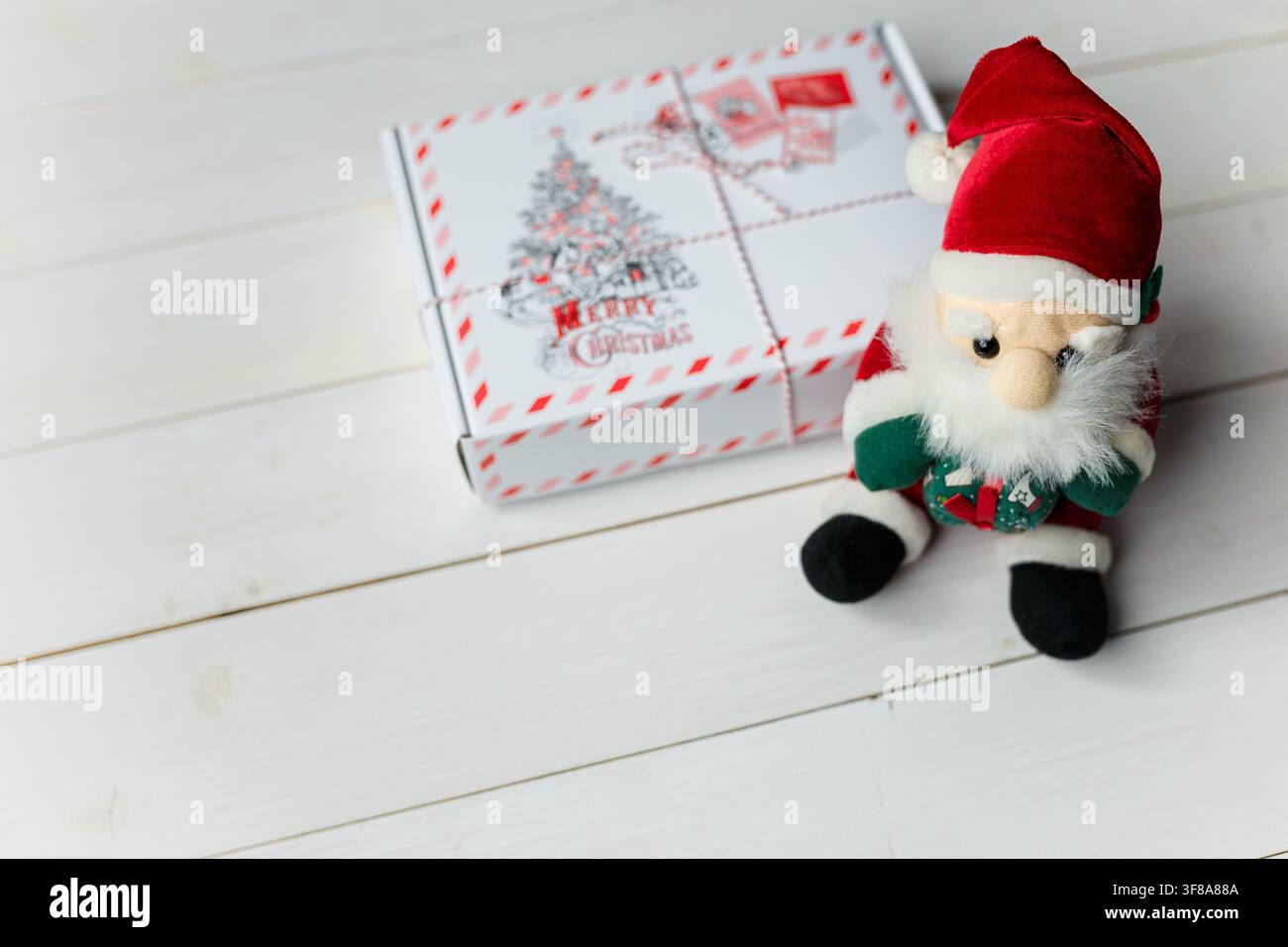 Izmail, Ukraine - 13 décembre 2019. Cadeau de Noël emballé et jouet du Père Noël sur une table en bois blanc. Concept de vacances d'hiver. Espace pour le texte Banque D'Images