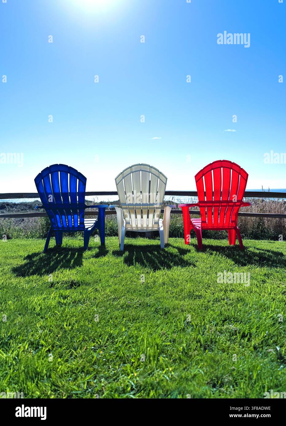 Chaises de jardin rouges, blanches et bleues ensemble vues de derrière. - Image de stock capturée avec un smartphone