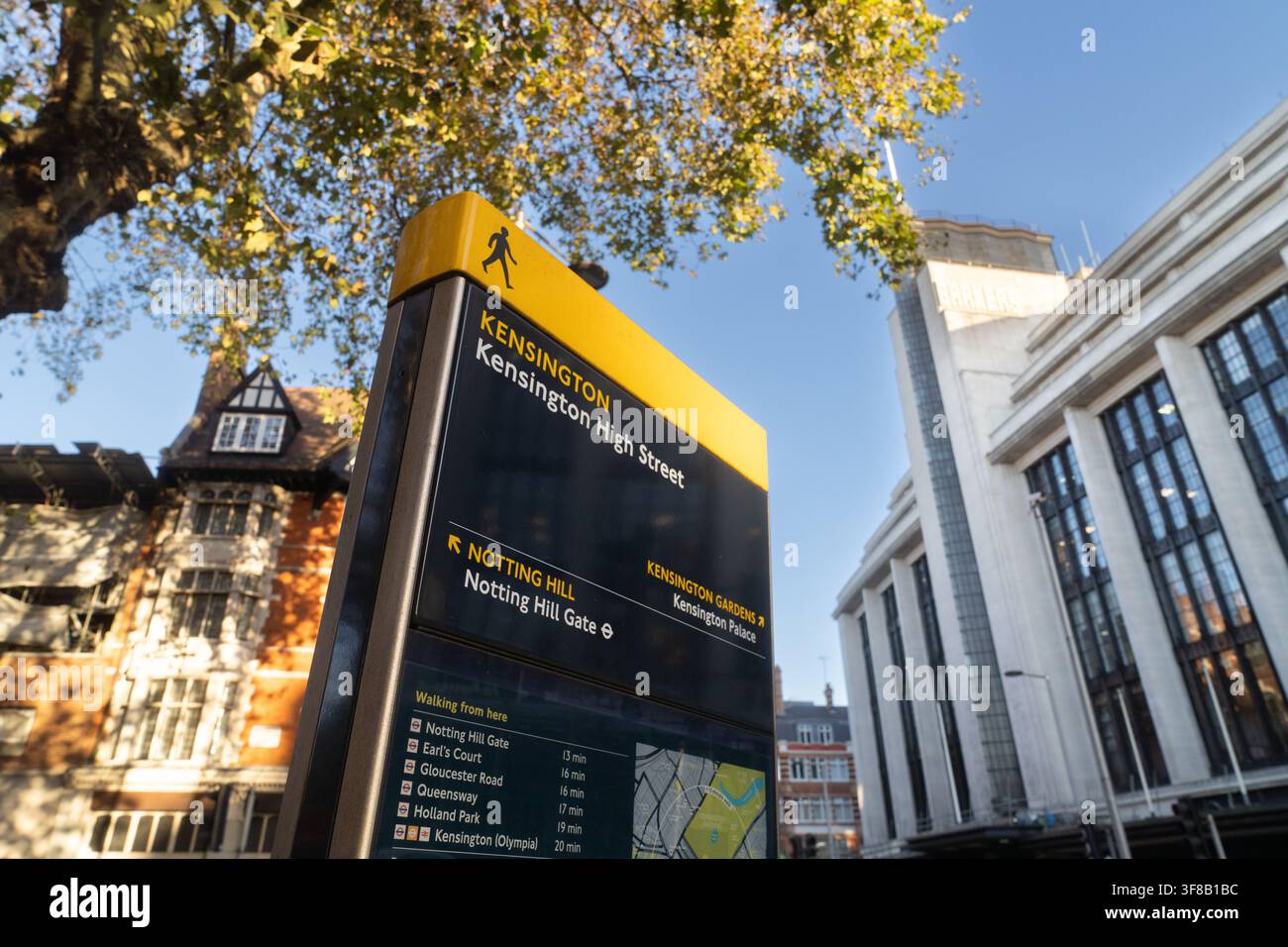 Un panneau d'orientation sur Kensington High Street à Londres indique aux visiteurs Notting Hill et le Kensington Palace près de l'historique bâtiment Barkers. Banque D'Images