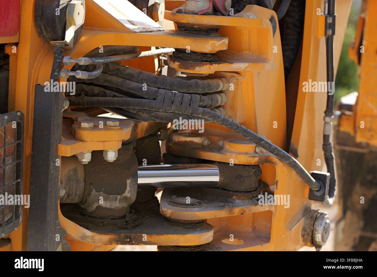 Piston hydraulique et tuyaux sont visibles sur le bras articulé d'une machine de construction lourde jaune, mettant en évidence l'ingénierie robuste de l'industrie Banque D'Images
