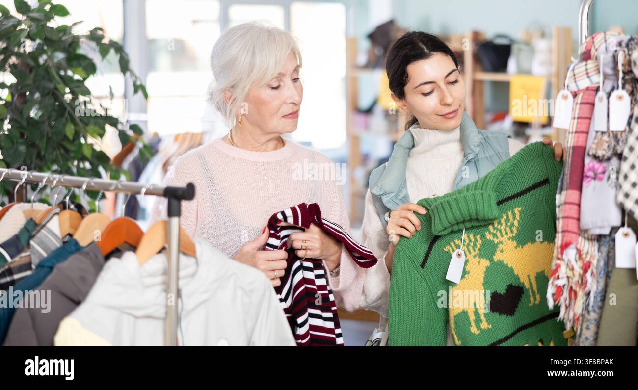 Mère âgée et sa fille adulte choisissent ensemble pull dans le magasin de vêtements Banque D'Images