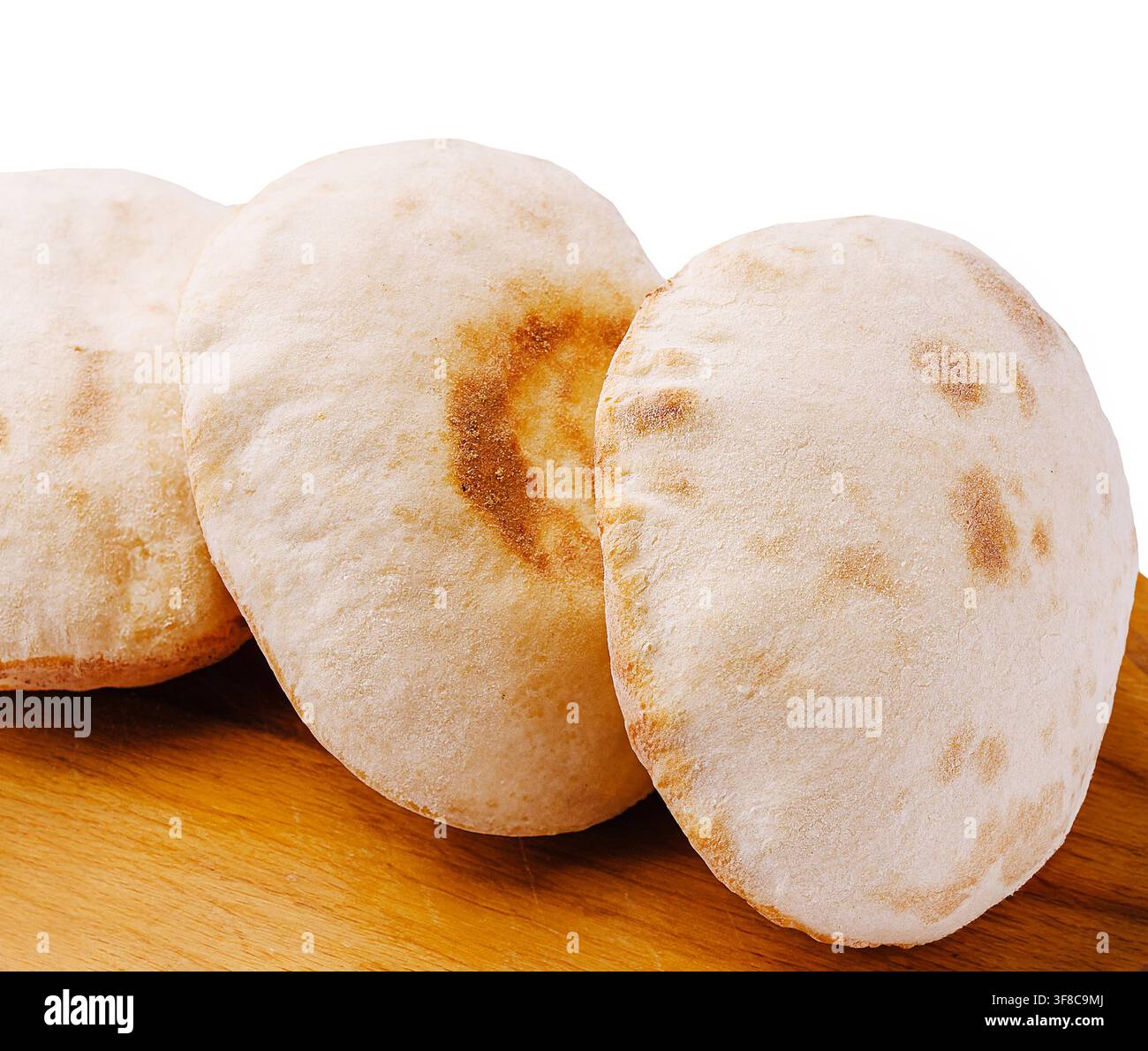 Du pain pita fraîchement cuit repose sur une surface en bois, mettant en valeur sa texture douce et ses légères taches dorées. Parfait pour divers plats ou trempettes, ce pain est un ajout délicieux. Banque D'Images