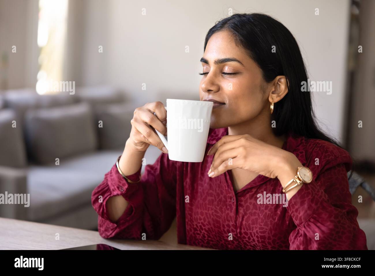 Jeune femme profitant d'un moment de paix avec son café du matin, gros plan Banque D'Images
