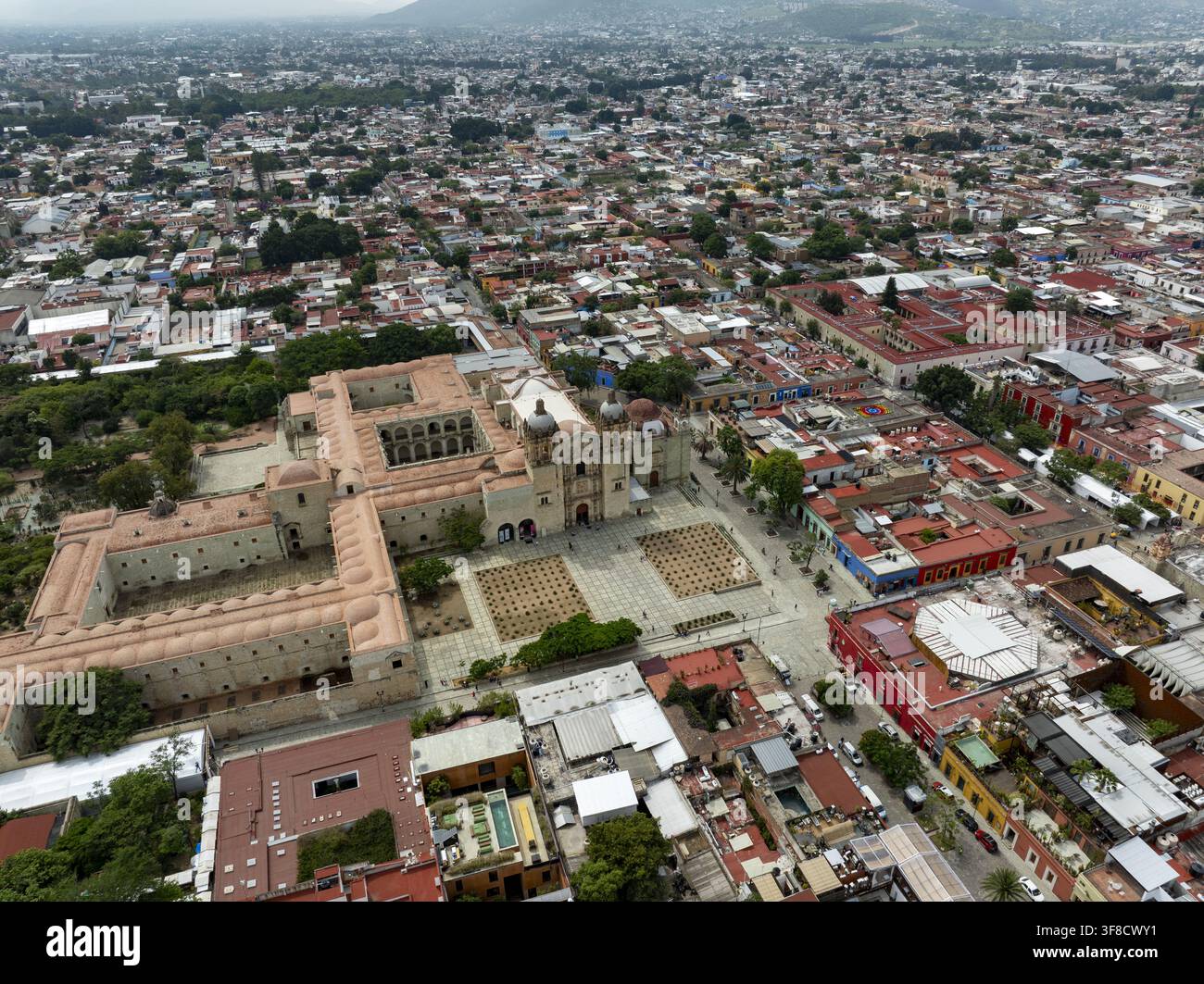 Vue aérienne du temple historique de Santo Domingo de Guzman entouré d'architecture coloniale, de toits aux tuiles rouges et de rues urbaines à Oaxaca de Banque D'Images