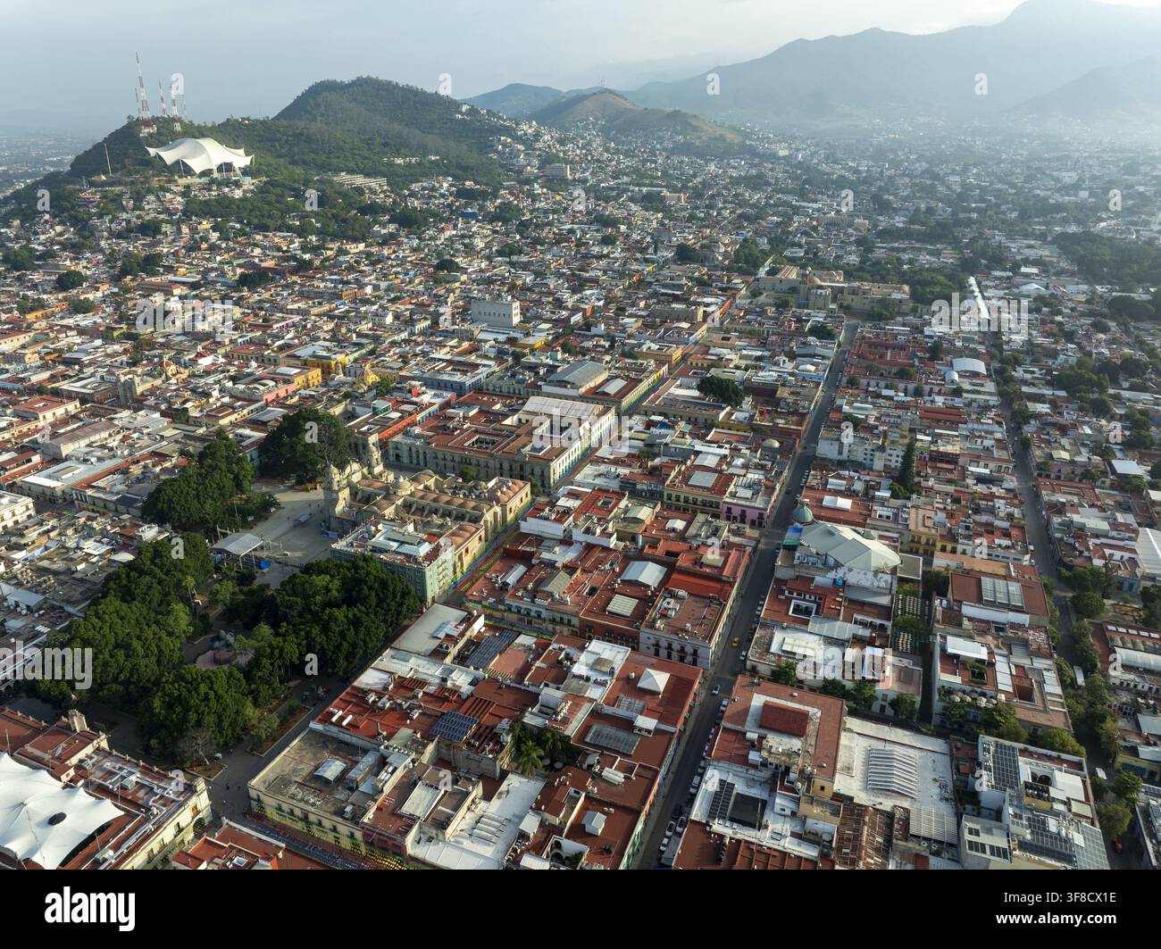 Vue aérienne de la ville historique d'Oaxaca de Juarez avec son architecture coloniale, ses toits aux tuiles rouges et la cathédrale, entourée de montagnes dans Banque D'Images
