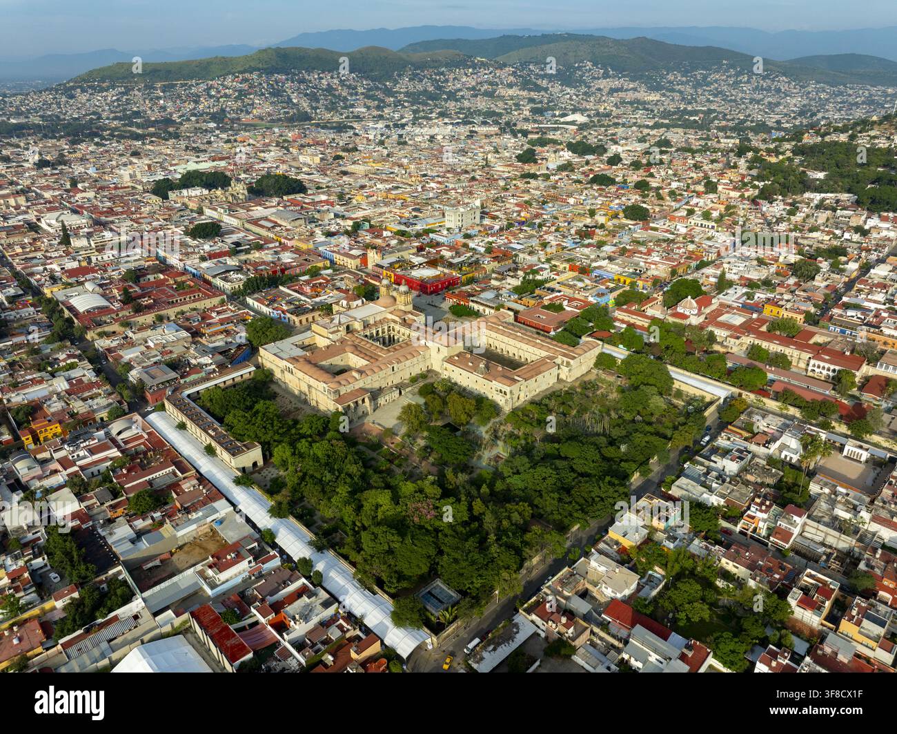 Vue aérienne du temple historique de Santo Domingo de Guzman entouré de toits coloniaux, de jardins luxuriants et du paysage urbain d'Oaxaca de Juar Banque D'Images