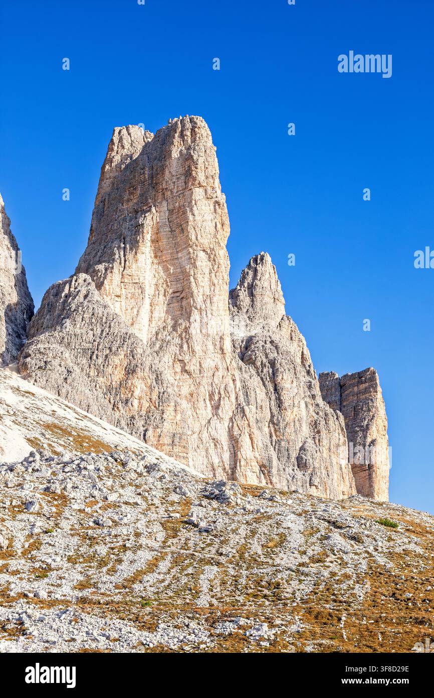 Tours rocheuses alpines s'élevant au-dessus d'une pente montagneuse escarpée Banque D'Images