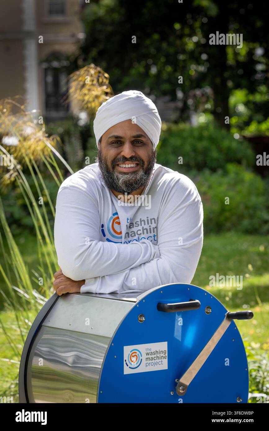 Dr. Navjot Sawhney, fondateur du projet The Washing Machine Project, pose avec sa machine à laver 'Divya' fonctionnant manuellement et hors réseau dans le nord de Londres, Royaume-Uni. Banque D'Images
