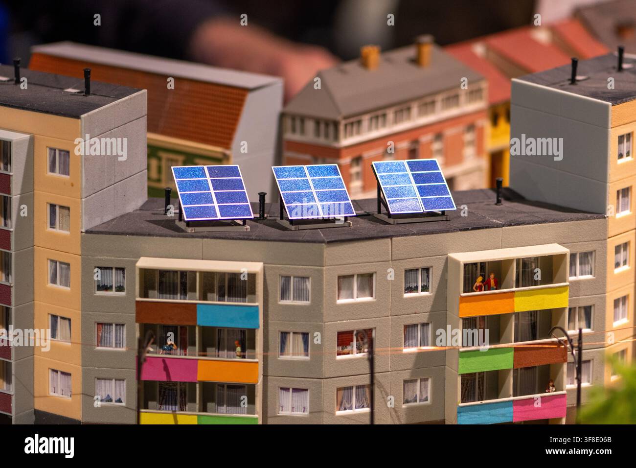 Une vue rapprochée montre un modèle réduit d'immeuble d'habitation avec des panneaux solaires sur le toit et des balcons colorés. Banque D'Images