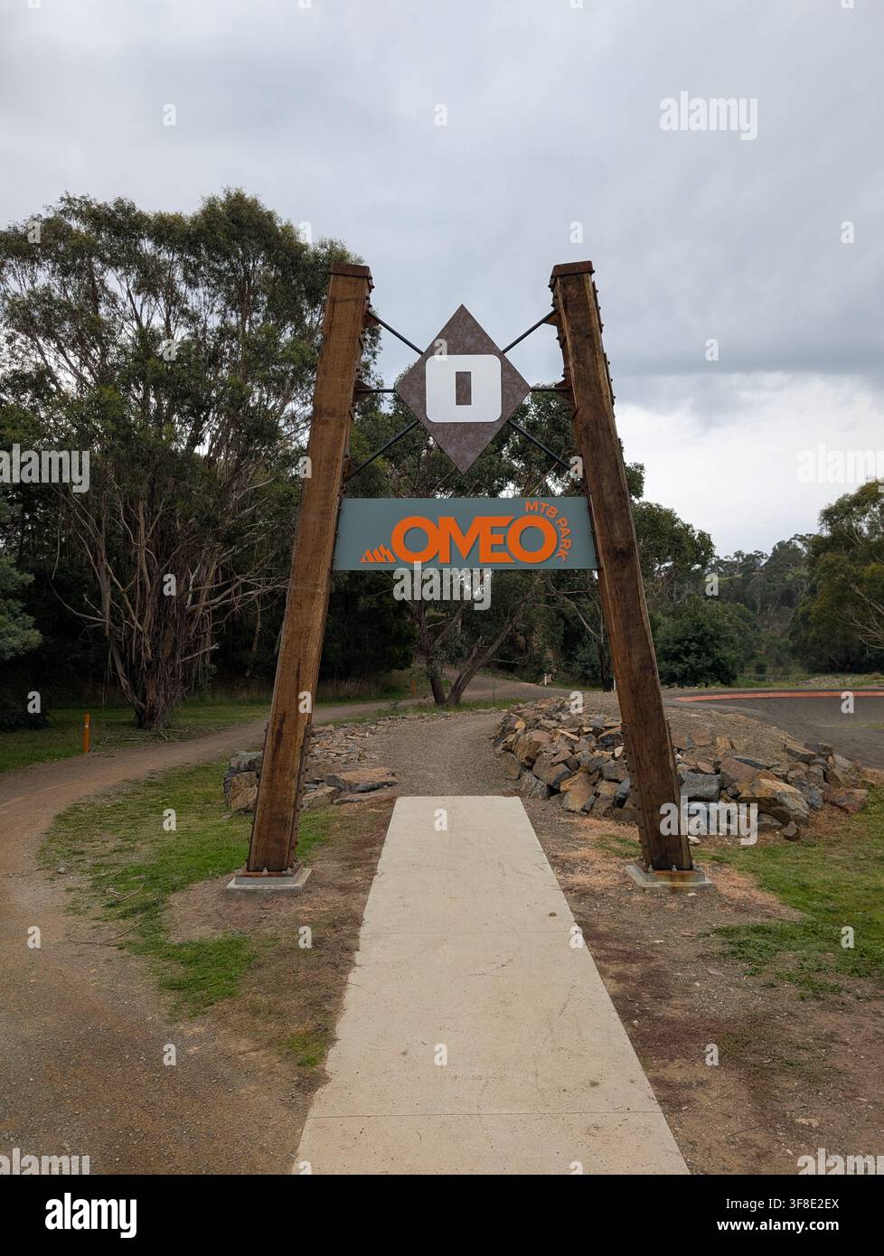 Omeo, Australie - 6 avril 2026 : Grand panneau d'entrée en bois pour le parc de vélo de montagne d'Omeo dans la région rurale de Victoria. Un chemin en béton mène à des sentiers en terre avec pu Banque D'Images