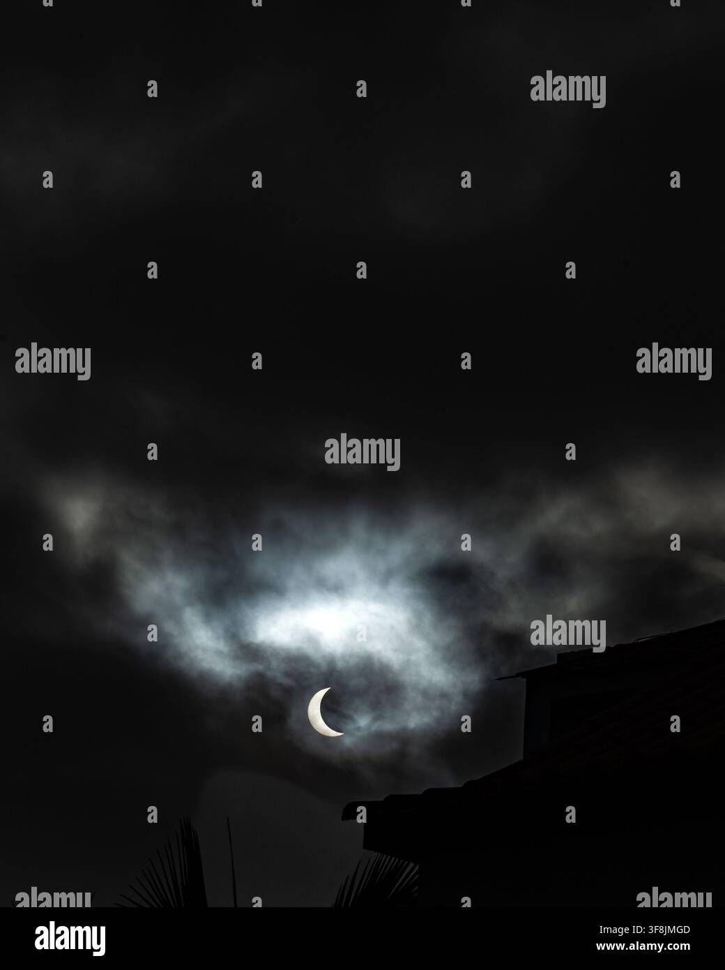 Éclipse solaire partielle photographiée à travers des nuages sombres dramatiques sur Madère, Portugal, le 12 août 2026, lors de l'éclipse solaire totale mondiale Banque D'Images