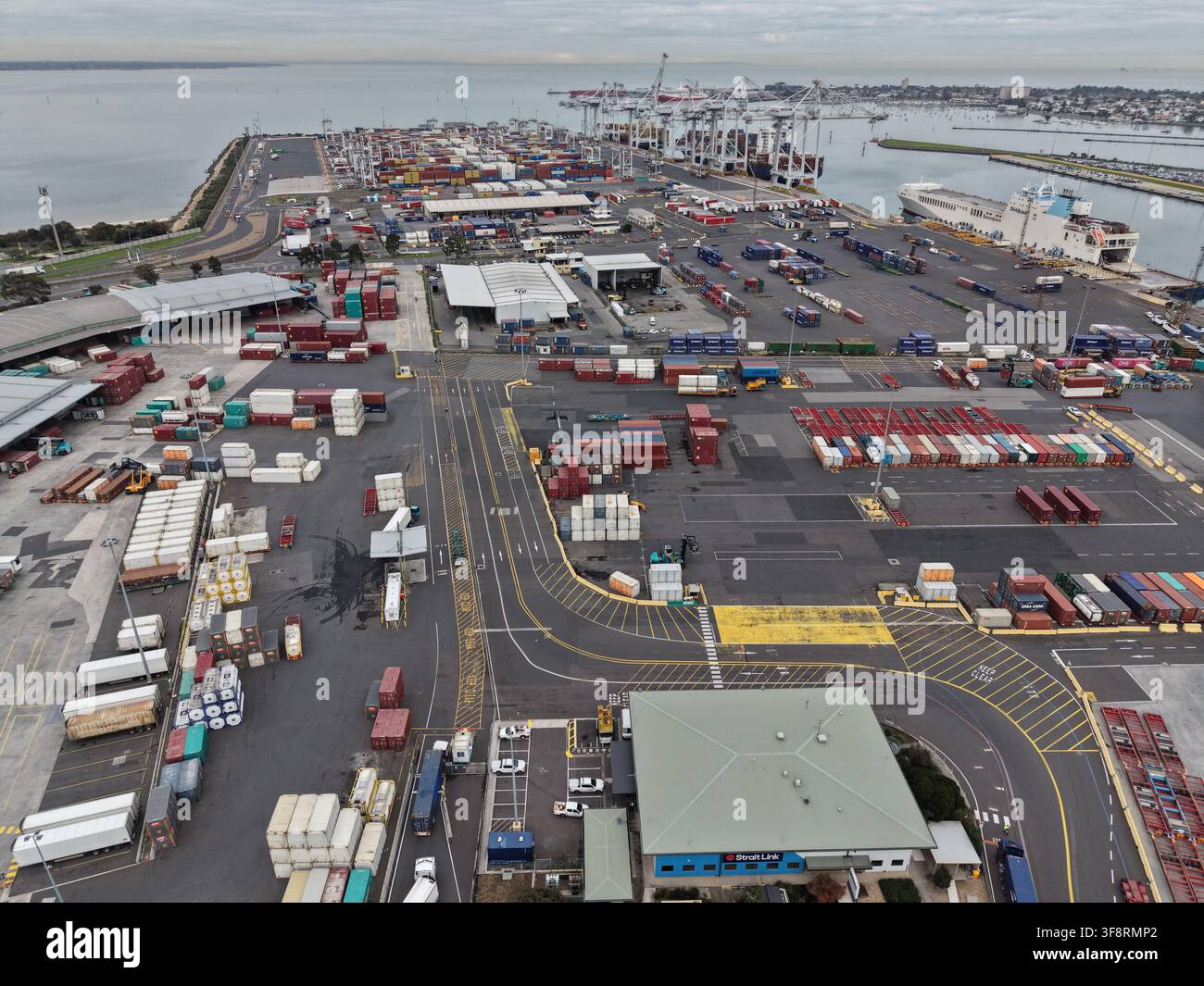 Vue aérienne du port de Melbourne montrant des conteneurs d'expédition empilés, des véhicules de marchandises et des navires de charge dans le terminal commercial animé Banque D'Images