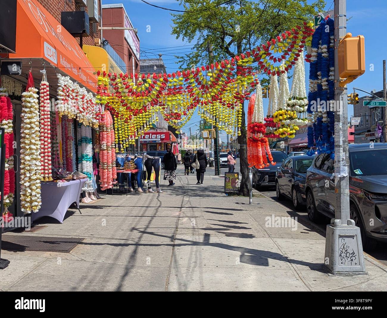 Guirlandes de fleurs artificielles utilisées comme décoration pour les fêtes hindoues, souvent arborant des couleurs vives – rouge, jaune et blanc – dans la Liberty Avenue, NY. - Image de stock capturée avec un smartphone