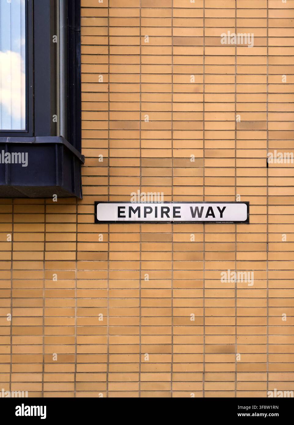 Photographie abstraite d'un mur de briques à motifs, d'une fenêtre et d'un panneau de nom de rue pour Empire Way, Cardiff Bay, South Wales, Royaume-Uni Banque D'Images