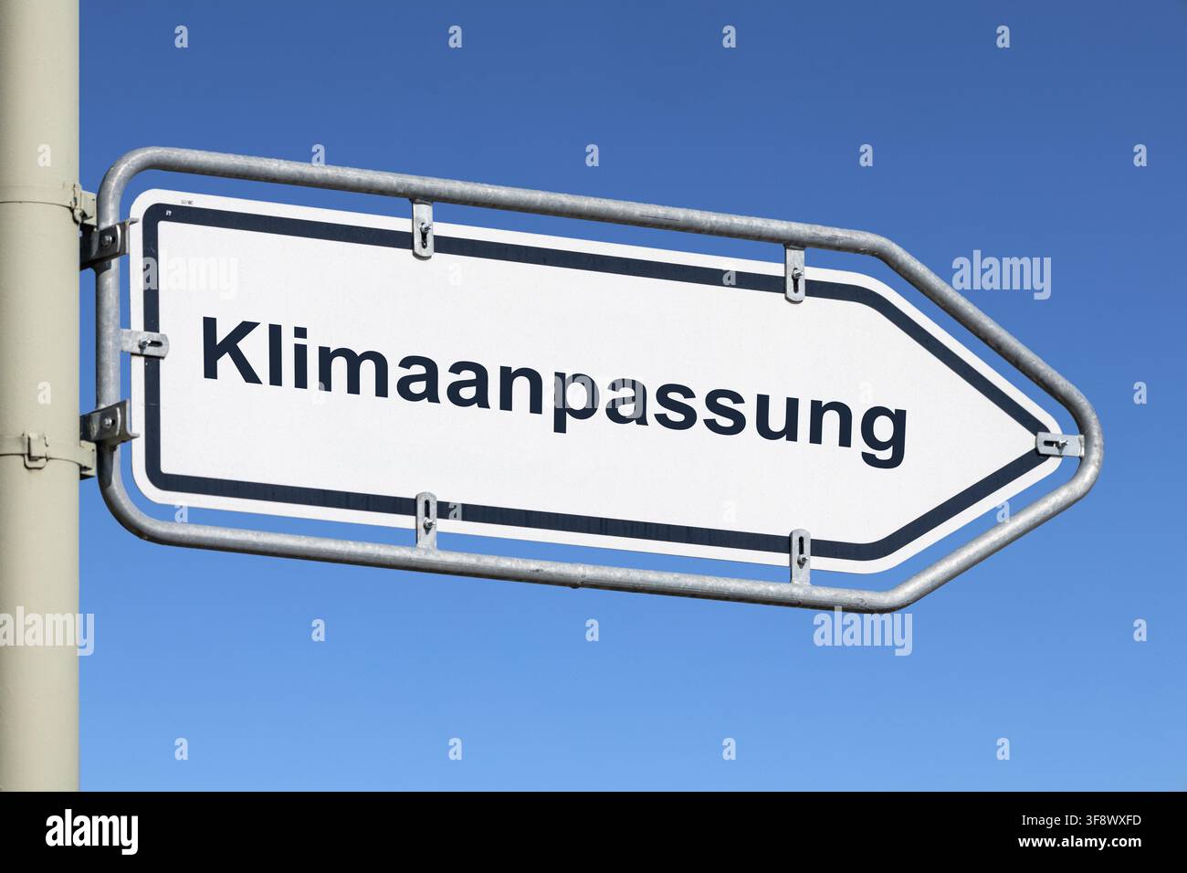 (Photomontage) Panneau indiquant KLIMAANPASSUNG (adaptation climatique) contre un ciel bleu Banque D'Images