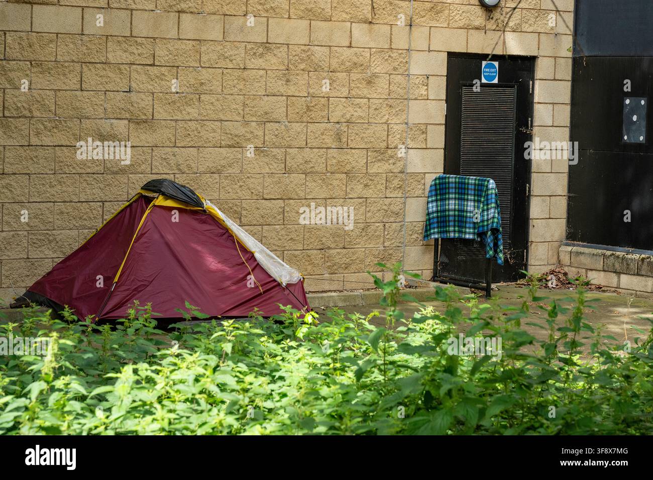 Tente de sans-abri contre le mur d'un centre sportif à Southampton, Angleterre, Royaume-Uni Banque D'Images