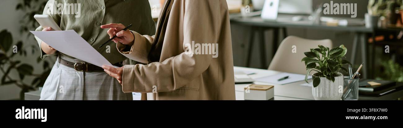 En-tête de deux femmes d'affaires examinant des documents dans un bureau moderne Banque D'Images