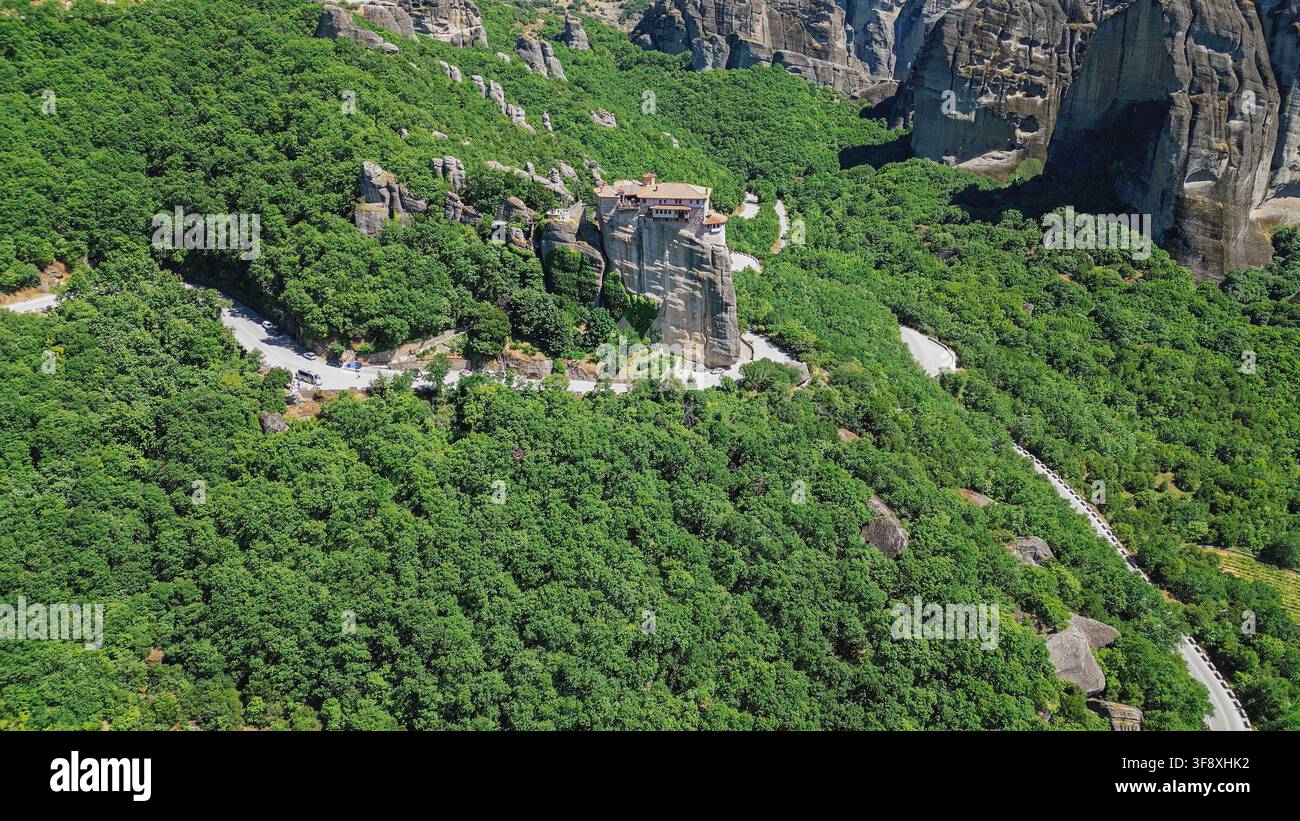 Vue aérienne du monastère orthodoxe de Rousanou construit au sommet d'une falaise escarpée entourée d'arbres d'une forêt dense, Meteora Kalabaka Grèce voyage st Banque D'Images