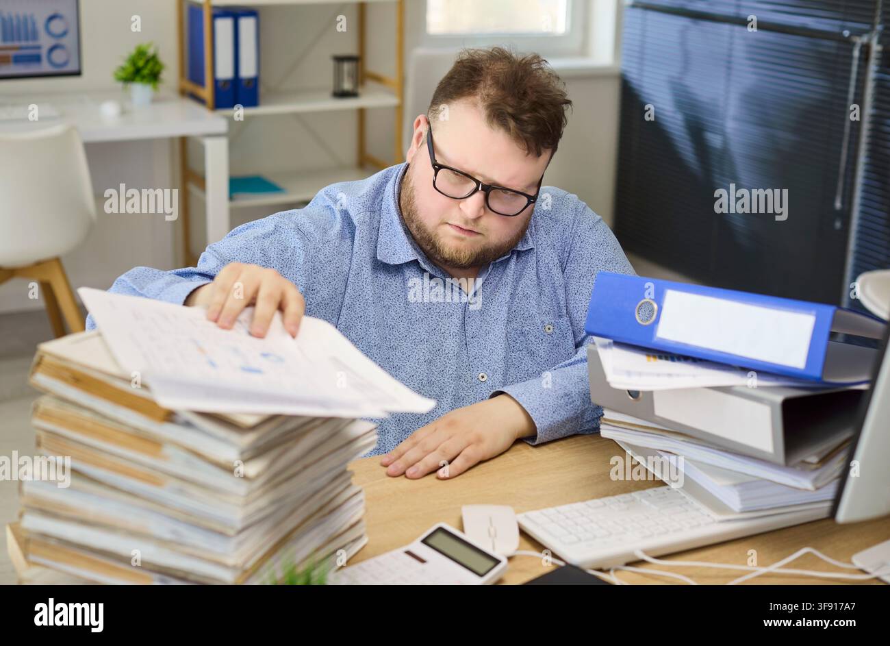 Comptable examinant des documents financiers au bureau lors d'un travail administratif concentré Banque D'Images