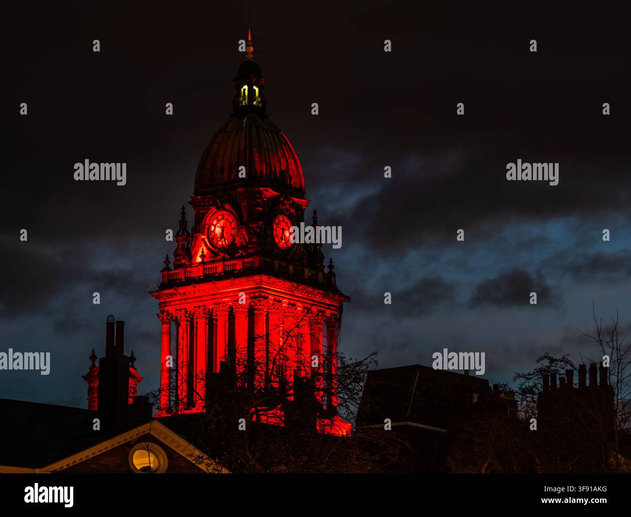 Vue de la tour de l'horloge de la mairie de Leeds illuminée en rouge la nuit Banque D'Images
