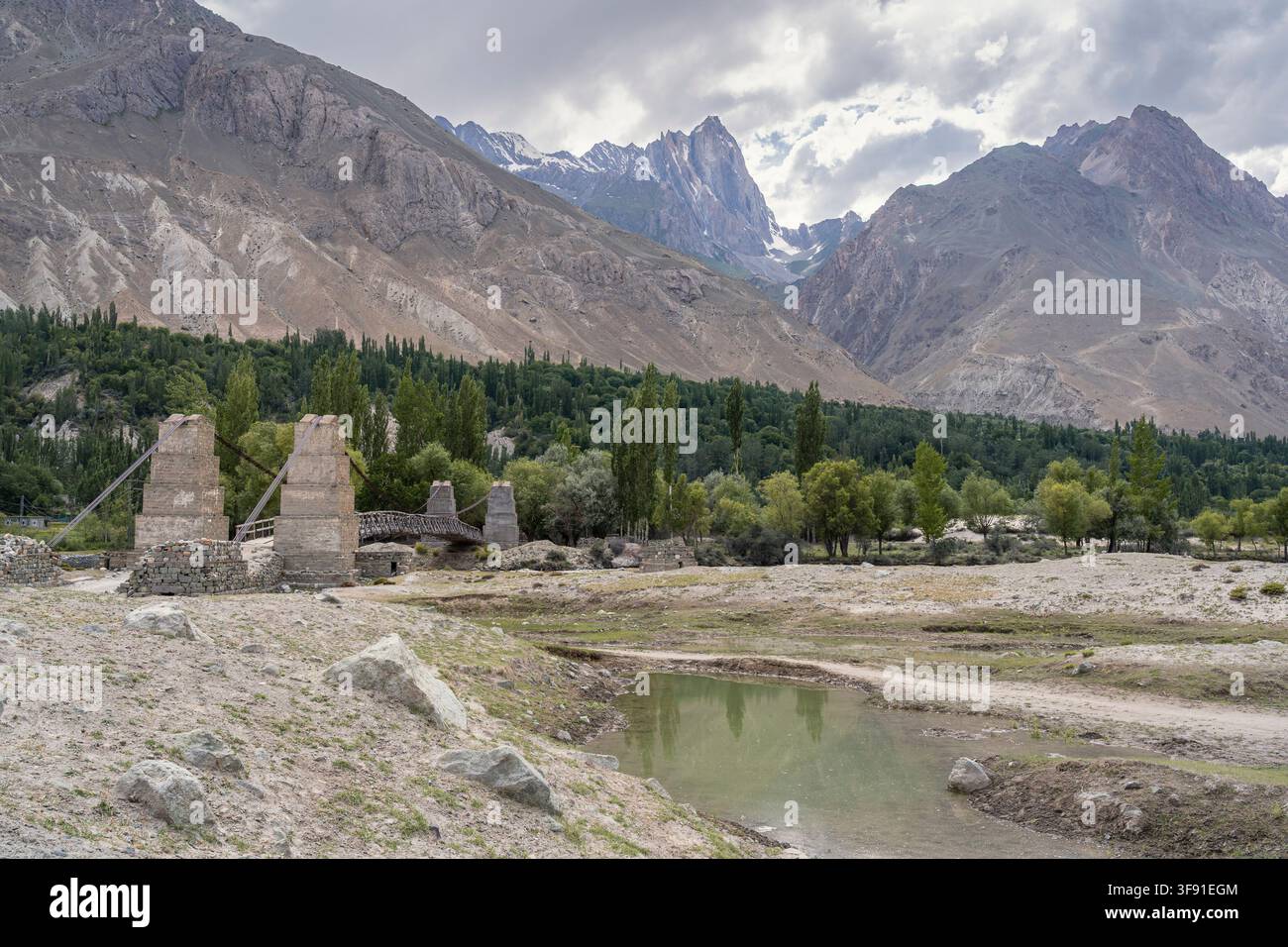 Vue panoramique d'un paysage d'été sur un pont dans la vallée de la rivière Shigar sous un ciel orageux, Shigar, Gilgit Baltistan, Pakistan Banque D'Images