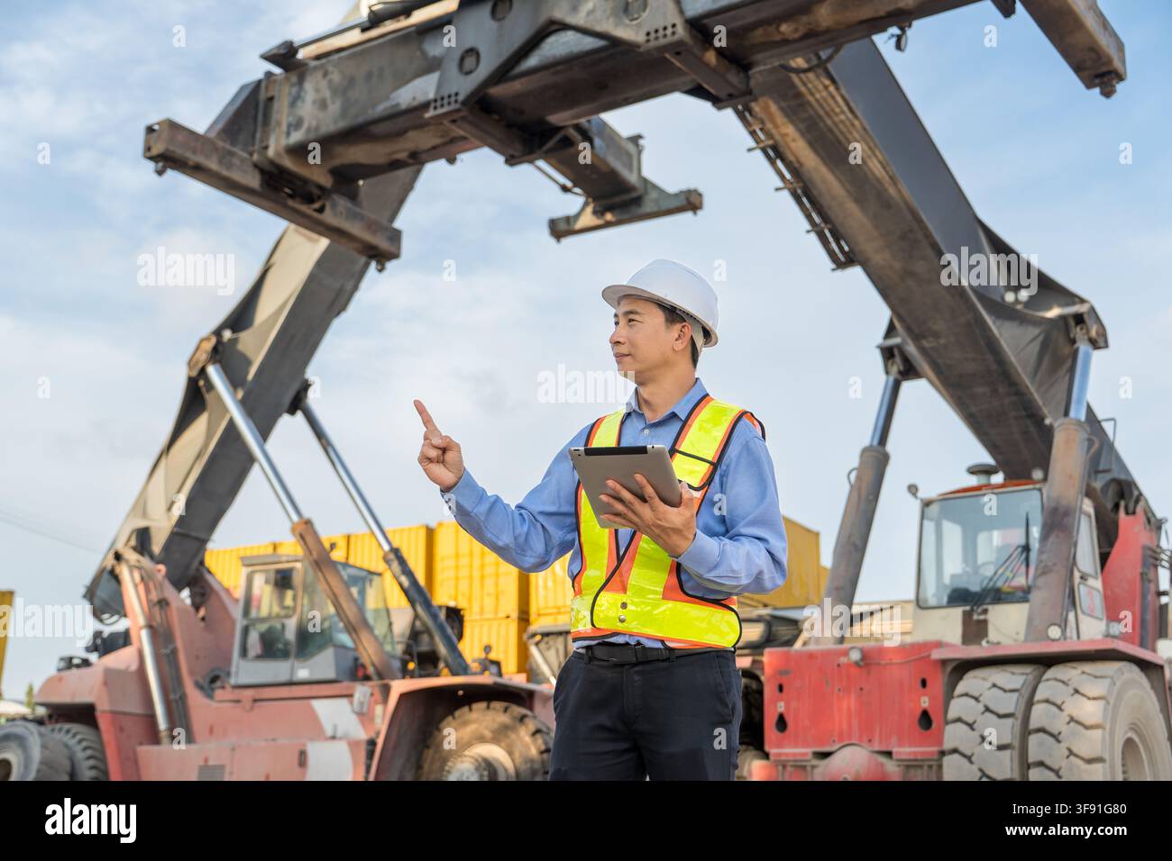 Gestionnaire de construction supervisant les opérations de machines sur un chantier pour garantir la sécurité et l'efficacité. Parfait pour les affaires, la construction, la gestion et où Banque D'Images