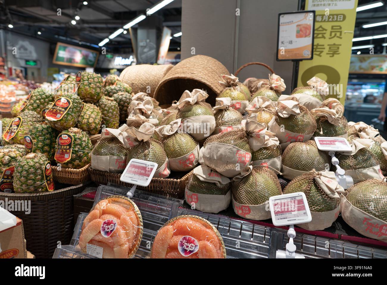 Shenzhen, Chine - 9 novembre 2025 : Pomelos et ananas exposés dans le rayon des produits frais d'un supermarché BLT Farm Market au centre commercial KK. Banque D'Images