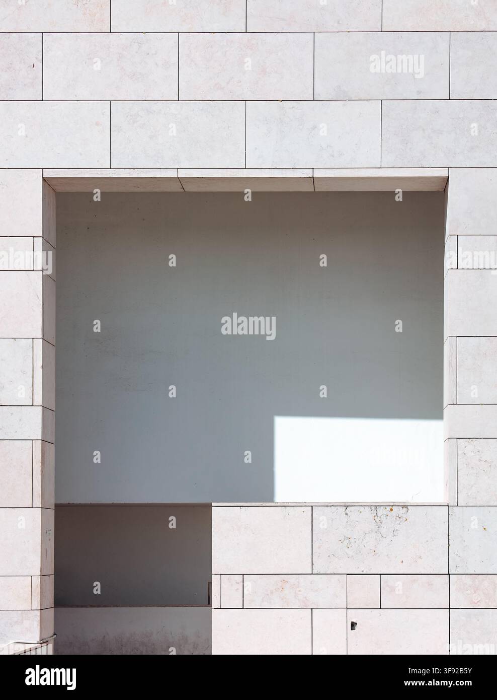 Façade de bâtiment minimaliste avec une ouverture de fenêtre géométrique Banque D'Images
