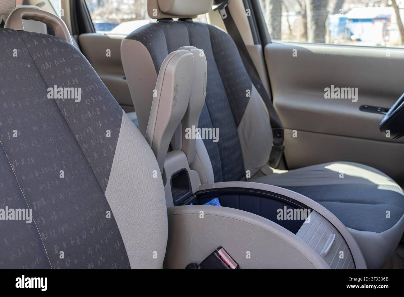 Bac de rangement vide dans la console centrale d'intérieur de voiture avec des housses de siège en tissu gris, illustrant un design automobile fonctionnel et un spa propre et bien rangé Banque D'Images