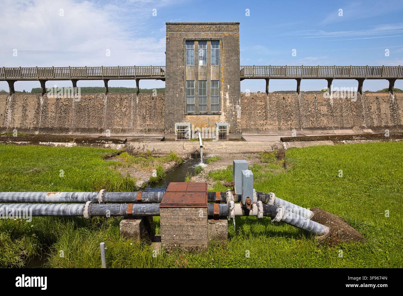 Vue symétrique du mur du barrage de Llyn Cefni, de la tour et des tuyaux de décharge d'eau près de Llangefni, île d'Anglesey, nord du Pays de Galles, Royaume-Uni. Banque D'Images