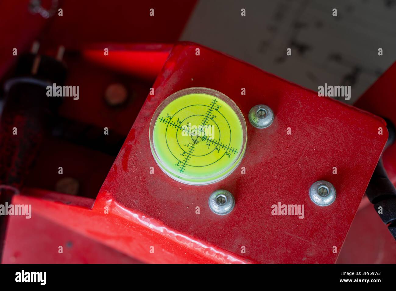 Jauge d'alésoir circulaire montée sur un cadre de machinerie industrielle rouge pour une mesure précise des angles et un contrôle du nivellement des surfaces Banque D'Images