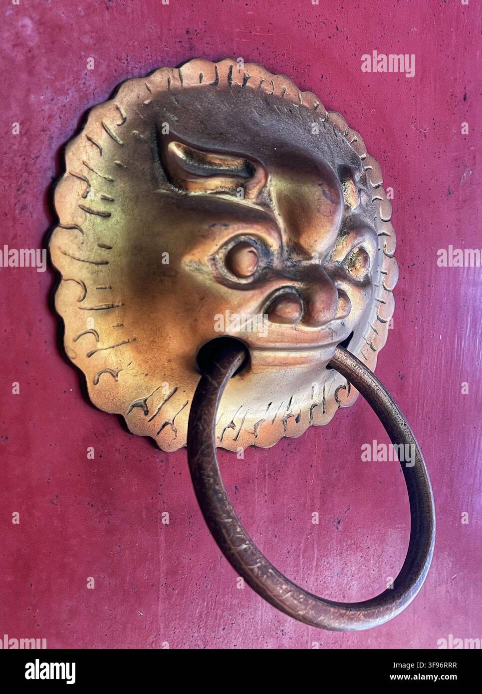 Heurtoir en tête de lion chinois sur une porte en bois rouge - Image de stock capturée avec un smartphone