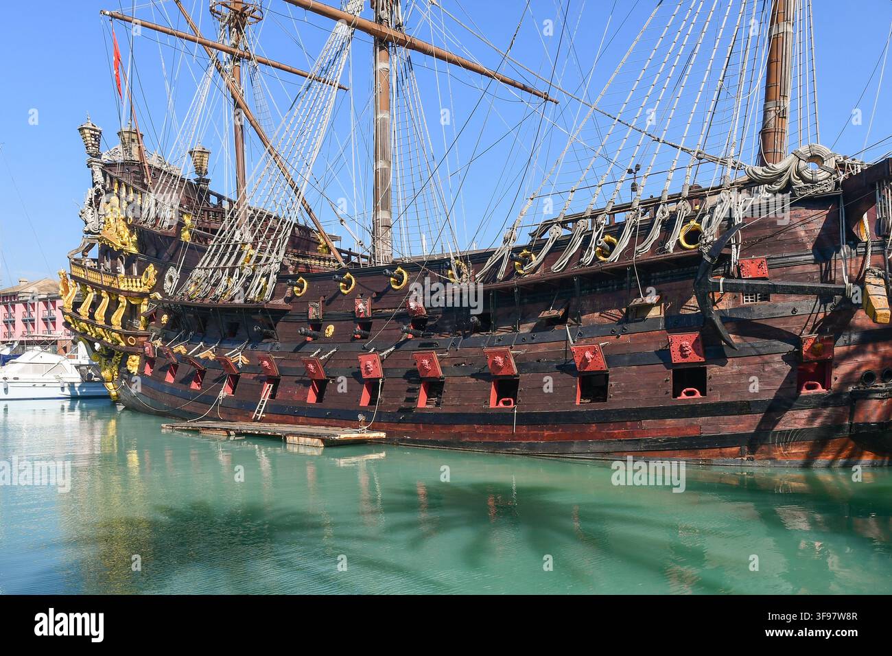 Vue latérale de la réplique du navire pirate galère Neptune montrant la coque en bois, les sabords ouverts et les riches décorations en or au Porto Antico de Gênes, Italie Banque D'Images