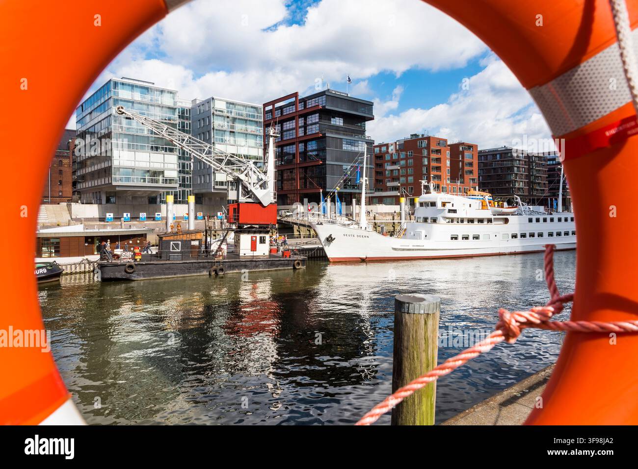 Vue à travers une bouée de sauvetage au musée du port avec de vieux grues et navires, entourés de résidences et bureaux modernes, ville portuaire, Hambourg, G Banque D'Images