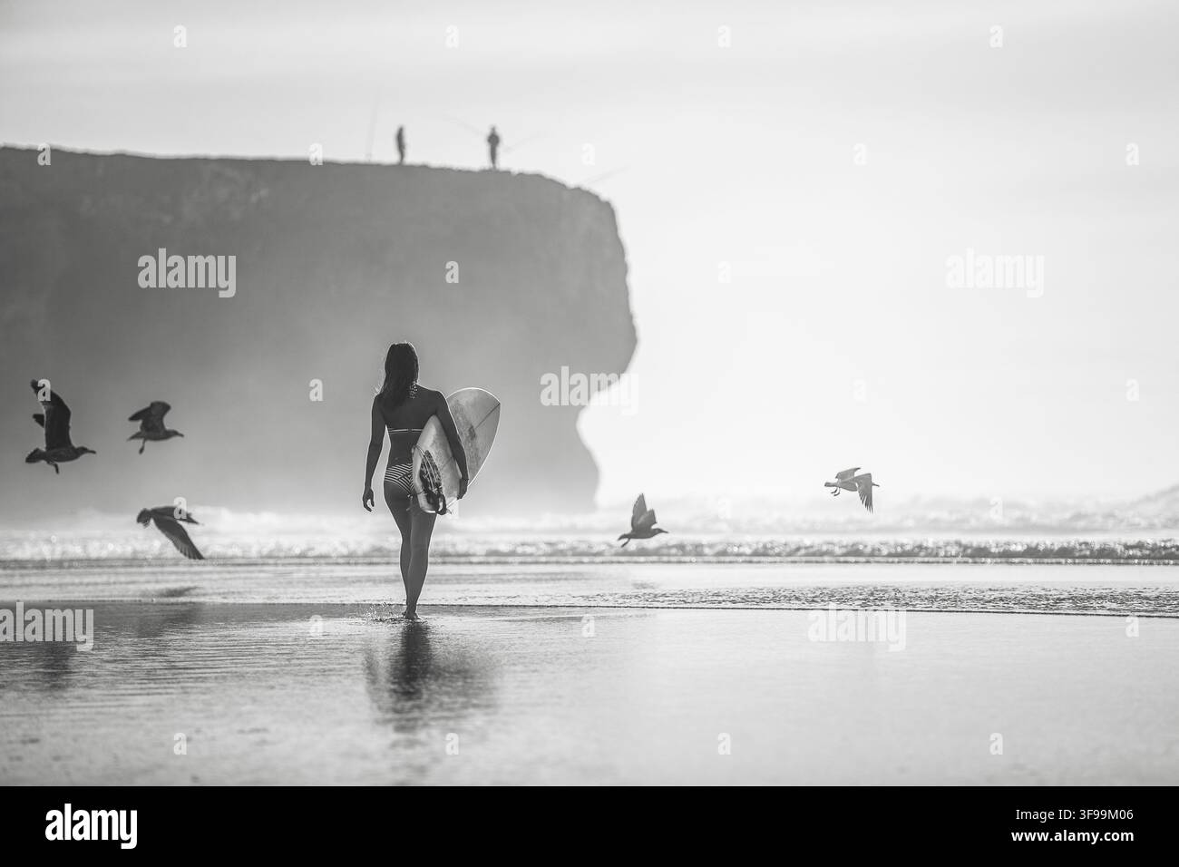 Une femme surfeuse marche sur la plage au Portugal avec sa planche de surf, surf, Portugal Banque D'Images