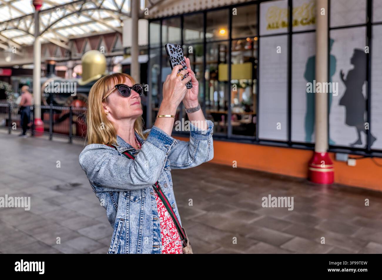 Un visiteur photographie l'intérieur du Windsor Royal Shopping dans la gare royale de Windsor restaurée. Banque D'Images