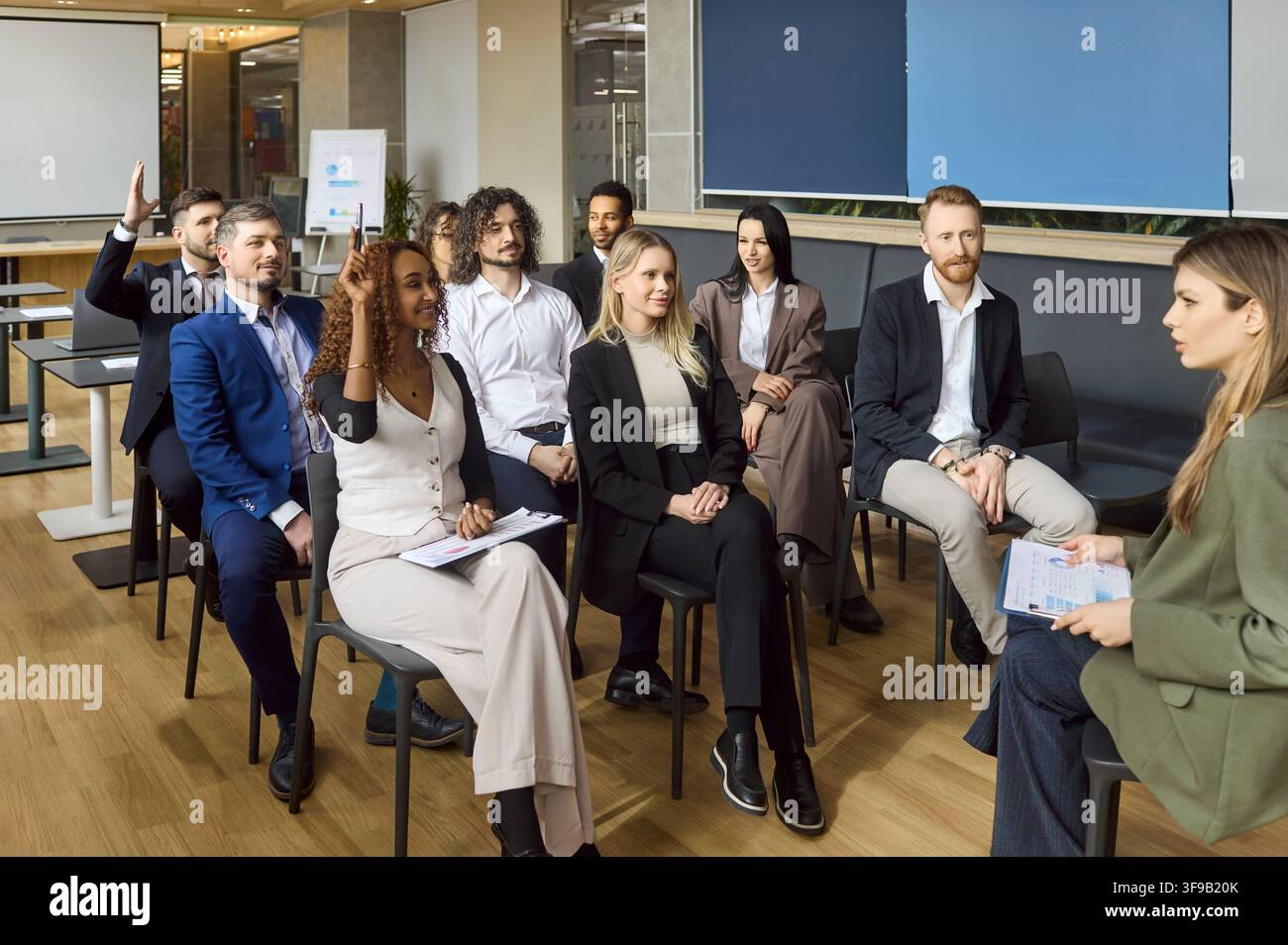 Équipe d'affaires diversifiée dans un atelier de bureau levant les mains pendant une formation d'entreprise Banque D'Images