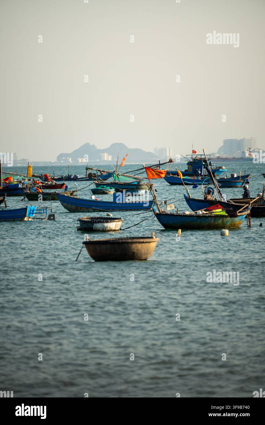 De nombreux bateaux de pêche traditionnels restent à l'ancre dans la baie du Vietnam après la capture matinale des fruits de mer. Banque D'Images