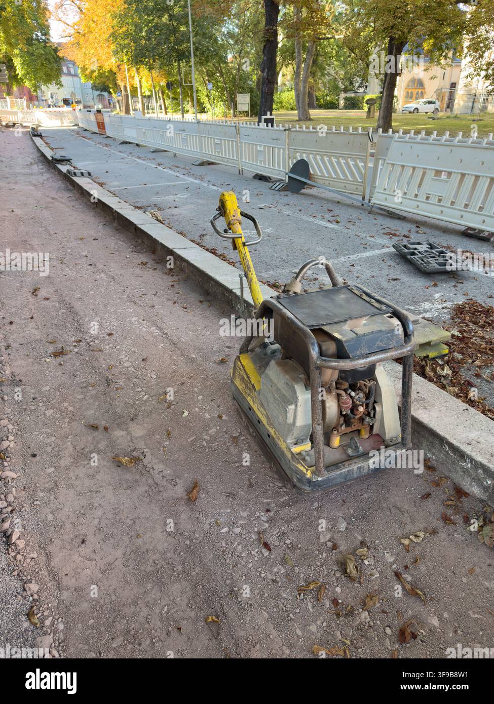 Compacteur de plaques sur un chantier de construction de chemin urbain – Travaux routiers, compactage du sol et développement des infrastructures Banque D'Images