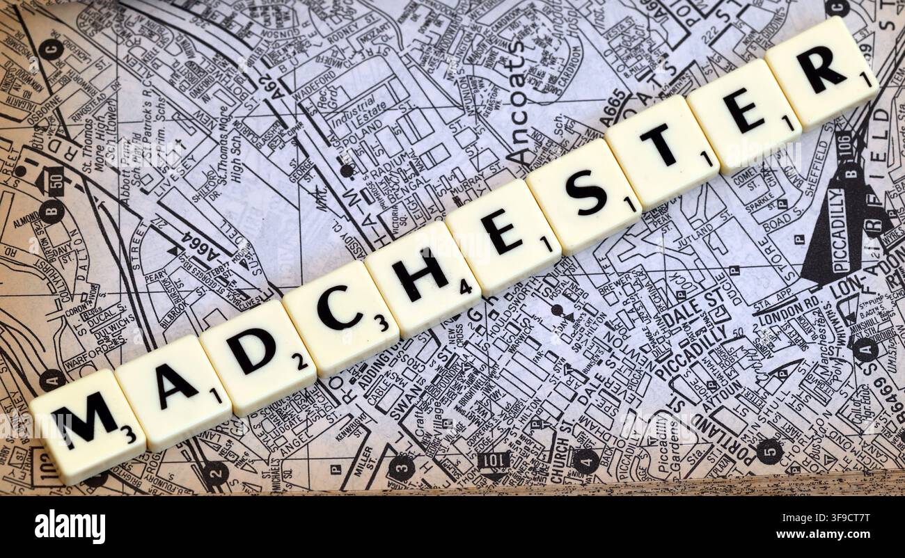 Tuiles lettres Madchester sur une carte imprimée de la ville de Manchester, évoquant la scène musicale Mad Frit et l'identité culturelle de la ville. Banque D'Images