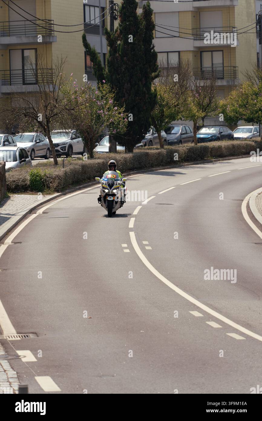 Maia, 16 août 2026 ; policier à moto assurant l'escorte d'un événement sportif sur une route urbaine. Banque D'Images