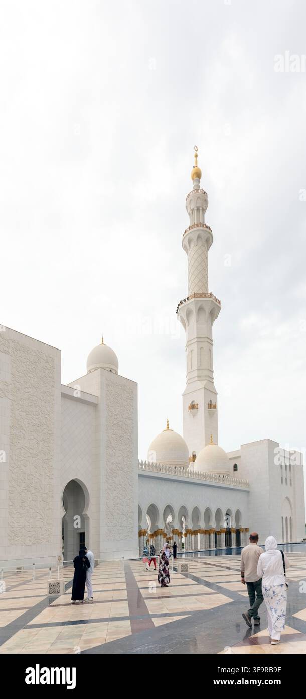 Personnes marchant à l'extérieur de la Grande Mosquée cheikh Zayed à Abu Dhabi, Émirats arabes unis, avec espace de copie Banque D'Images