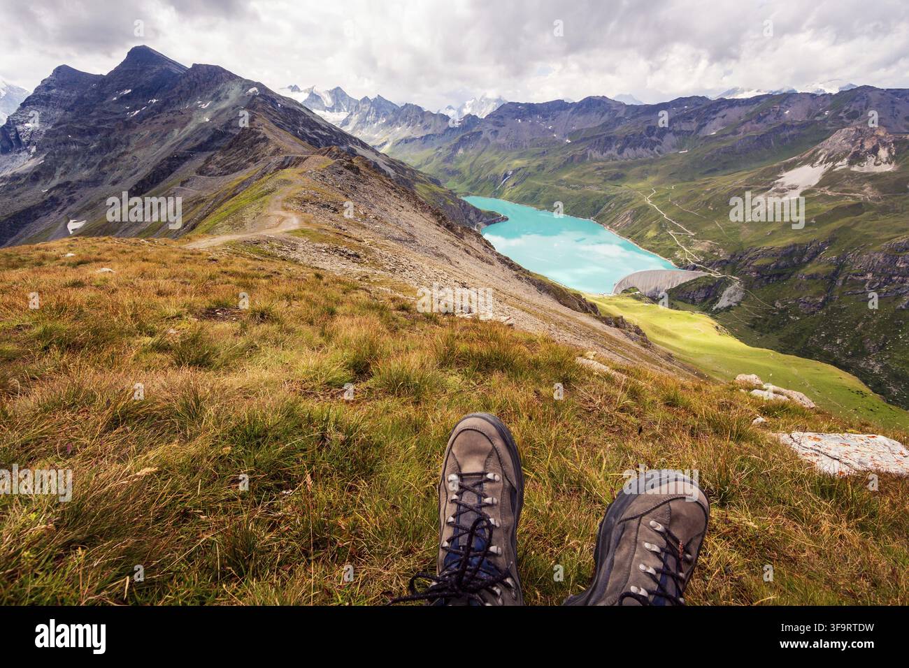 Profitez d'une vue à couper le souffle depuis le sommet d'une montagne sur un lac de montagne. Point de vue de la première personne sur les chaussures de randonnée. Corne De Sorebois, Grimentz, Valais, Banque D'Images