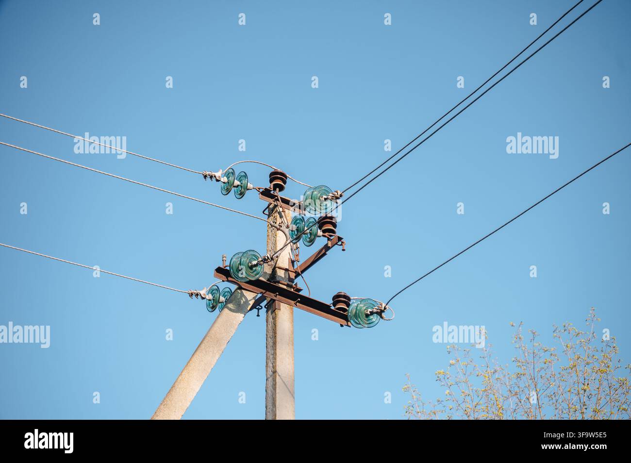 Ligne électrique avec fils et isolateurs contre un ciel bleu clair et lumineux, infrastructure énergétique. Photo de haute qualité Banque D'Images