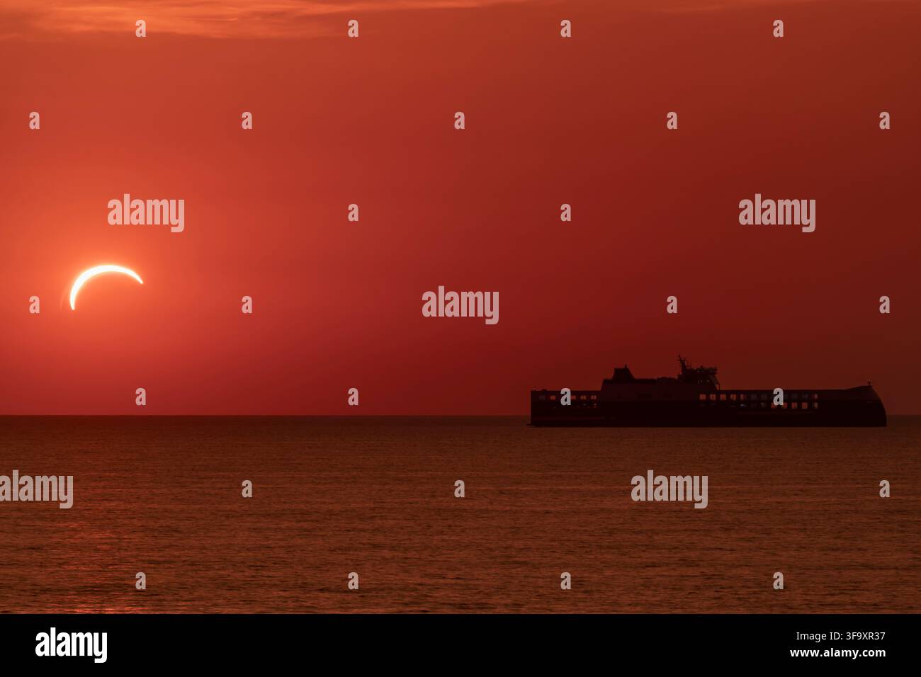 Un ferry navigue près du port de Livourne, en Italie, lors de l'éclipse solaire du 12 août 2026 Banque D'Images